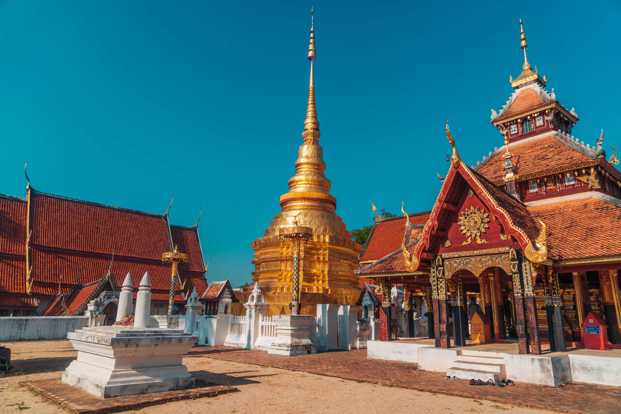 Ancient Lanna temples of Lampang in Thailand on a scenic Lampang Travel banner by Legend Travel Group.